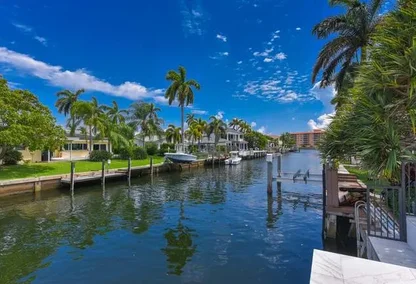 Waterfront view of canal homes in Harbour East, Boca Raton with private docks, boats, and tropical palm trees.